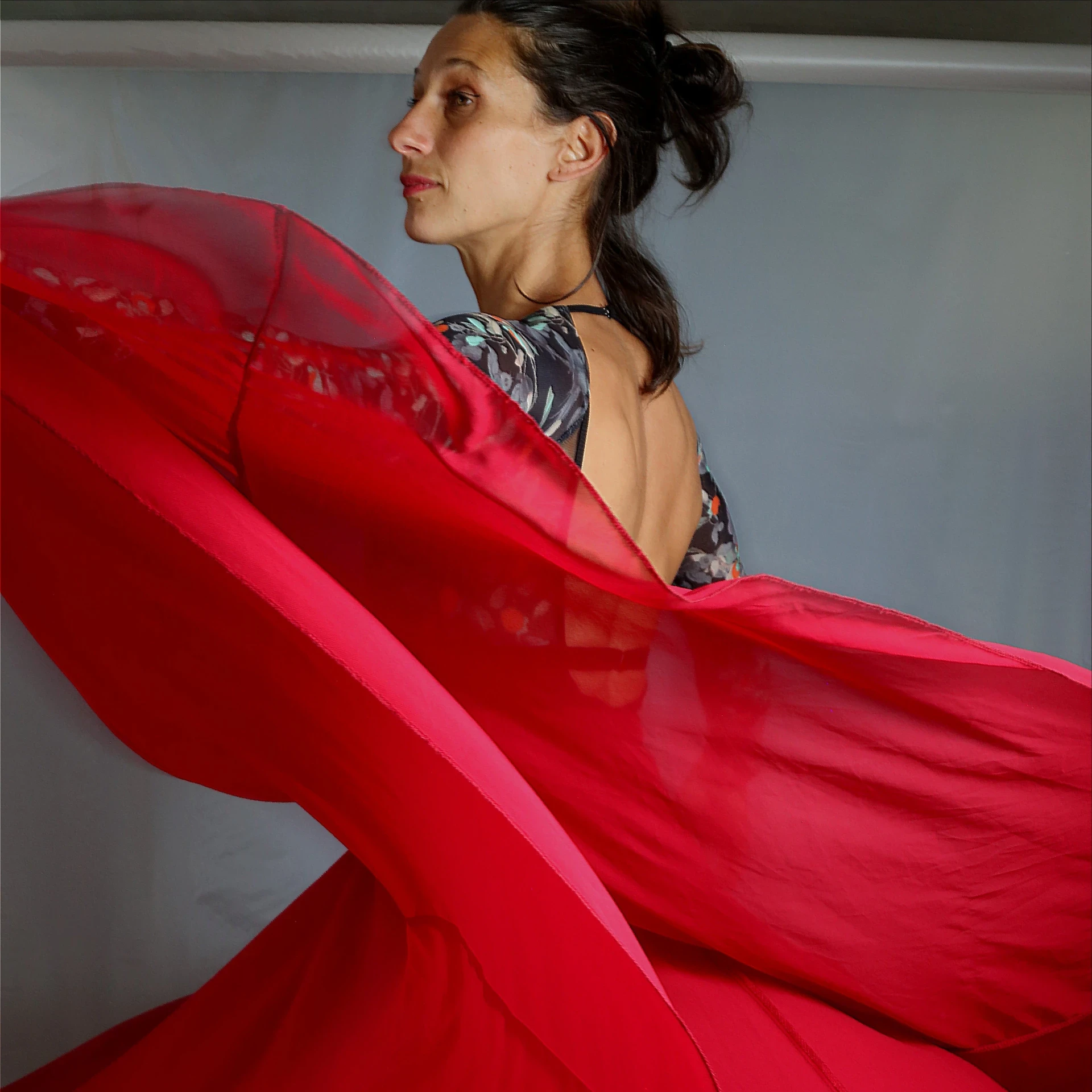 Elena Martino seitlich tanzend. Elena trägt einen roten Rock der in der Bewegung seitlich hochfliegt.